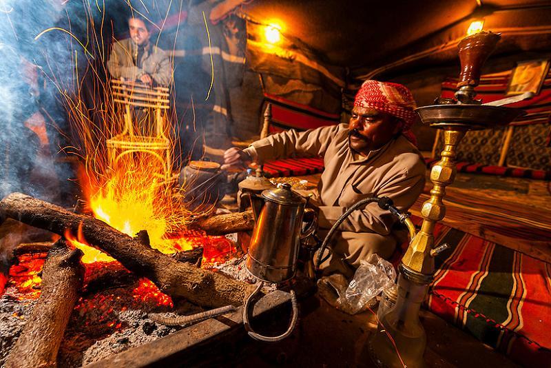 Bedouin Man Roasting Coffee Beans Over A Campfire At Captain's Desert Camp, Wadi Rum, Jordan