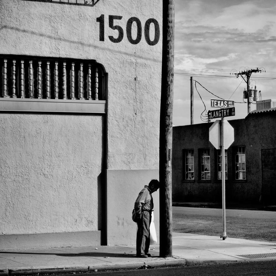 Man Leaning Against Pole