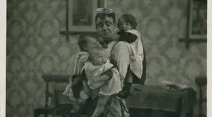 Man In An Apron Holding Children