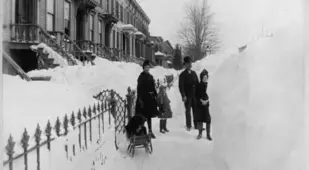 Family Outside Their Home Looking At A Wall Of Snow