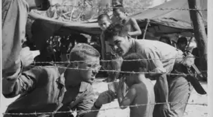 Soldiers Console Naked Child Behind Wire