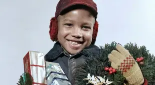 Black Boy Holding Presents And A Wreath