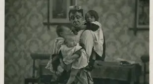 Man In An Apron Holding Children