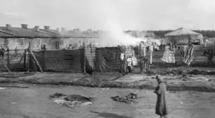 Prisoner Walks Along Barracks At Bergen-Belsen