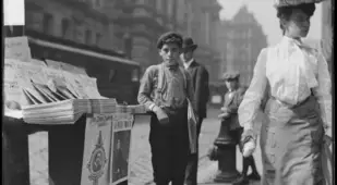 Newsboy Next To Paper Stand