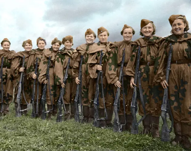 A Line Of Female Soldiers Smile While Holding Guns