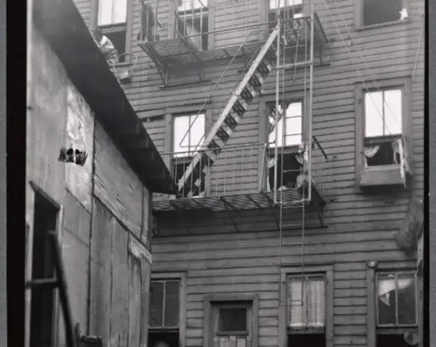 Little Girl In Window Tenement Building