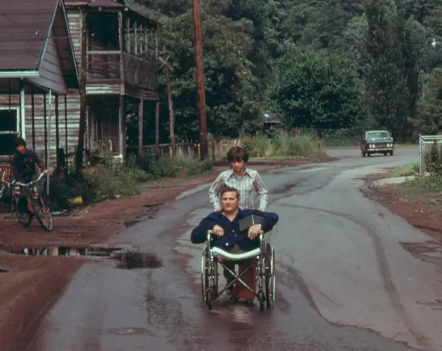 Disabled Miner Wheeled By His Daughter