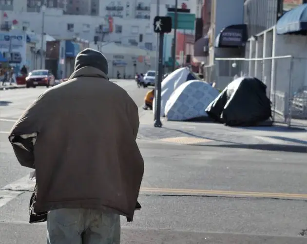 Man Crossing Street Toward Tents