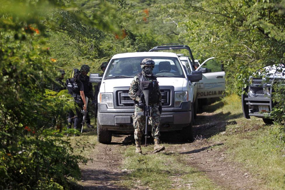 Mexican militia guard mass grave site