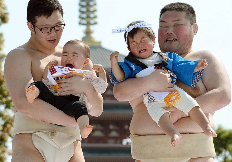 Sumo Wrestlers Hold Crying Babies