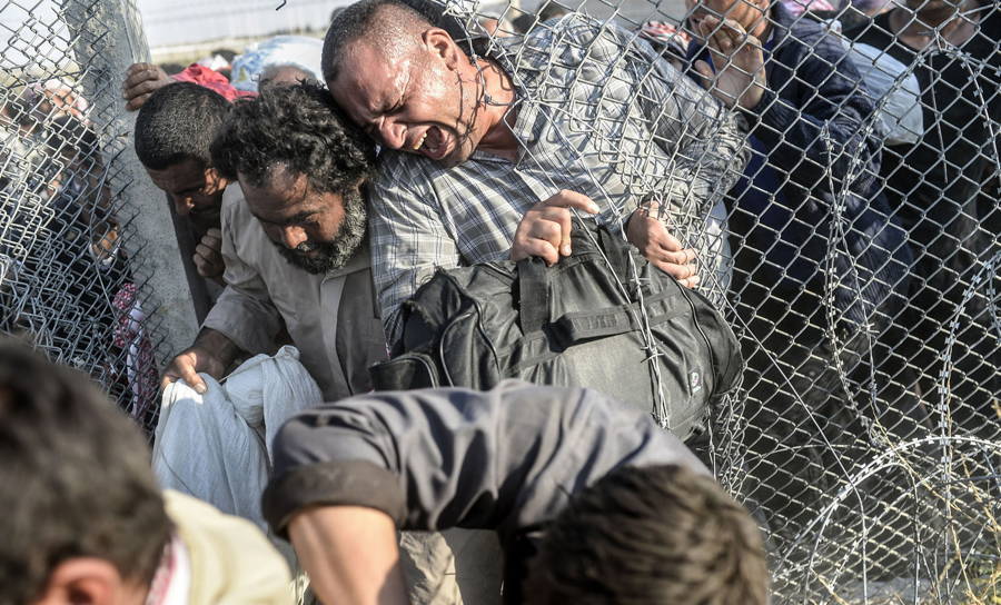 Syrian Refugees Squeeze Fence