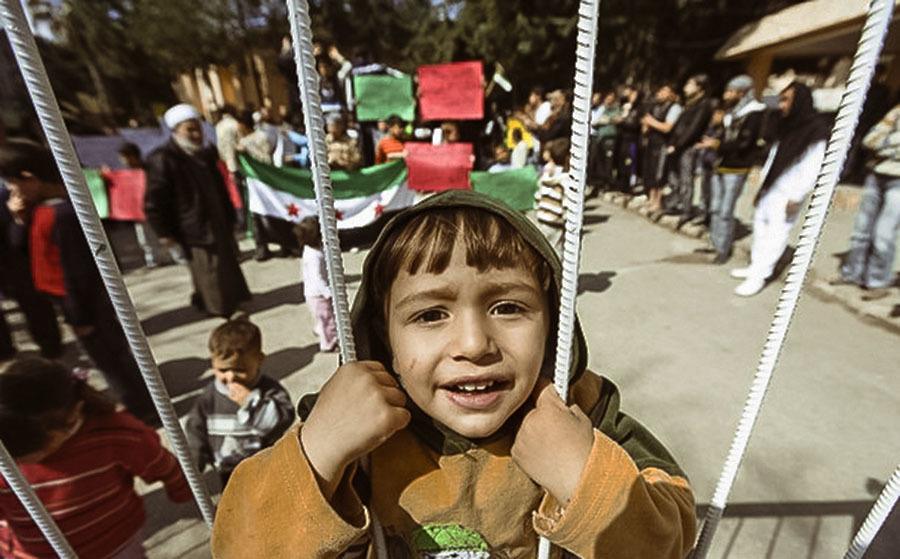 A Syrian Refugee Boy Stands Behind The Fence During Protest Against Syria's President Bashar Al Assad