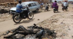 Commuters Drive Past The Burnt Corpse Of