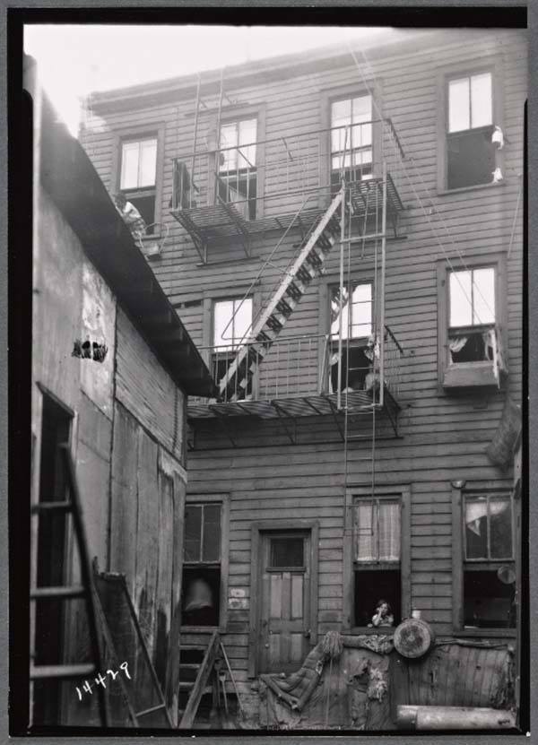 Little Girl In Window Tenement Building