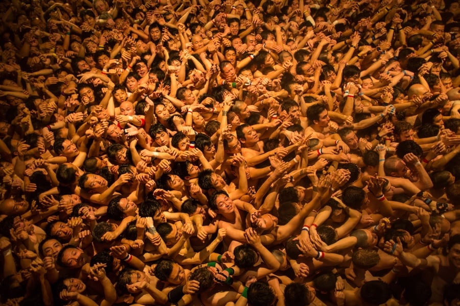 Hundreds of nudist people running into the sea naked