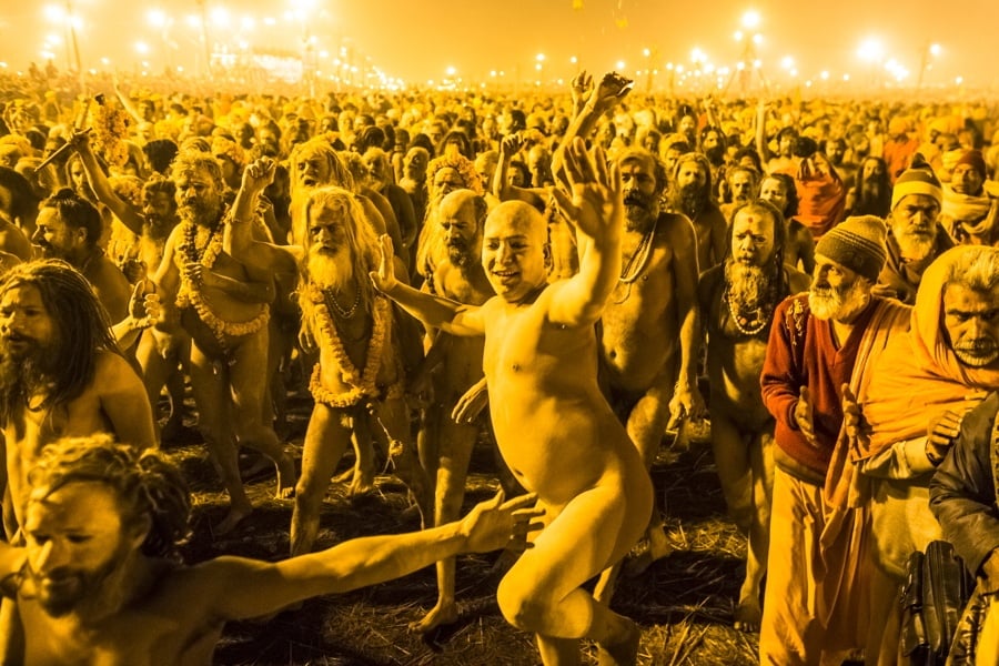 Hundreds of nudist people running into the sea naked