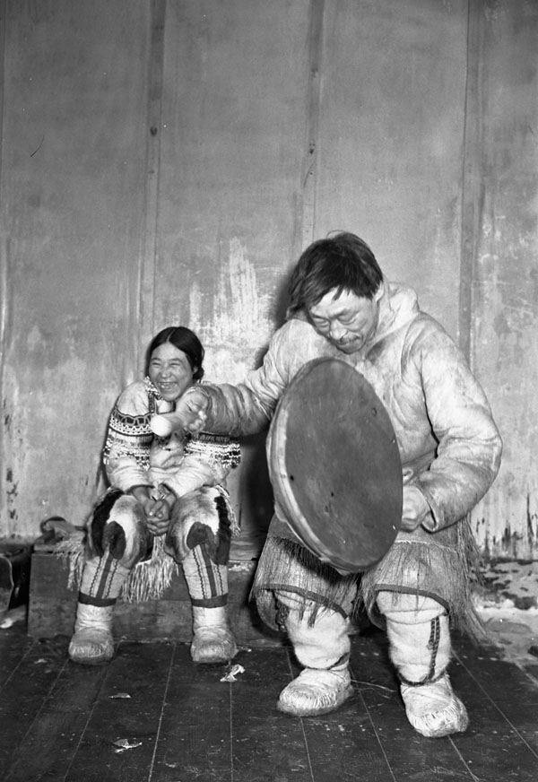 Inuit People Playing A Drum