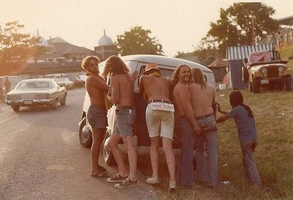 hippies empujando un vehiculo