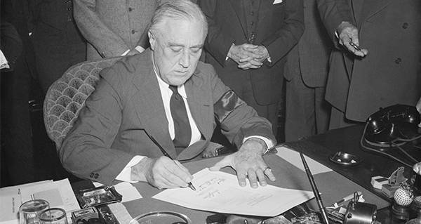 FDR signs a resolution declaring war on Japan