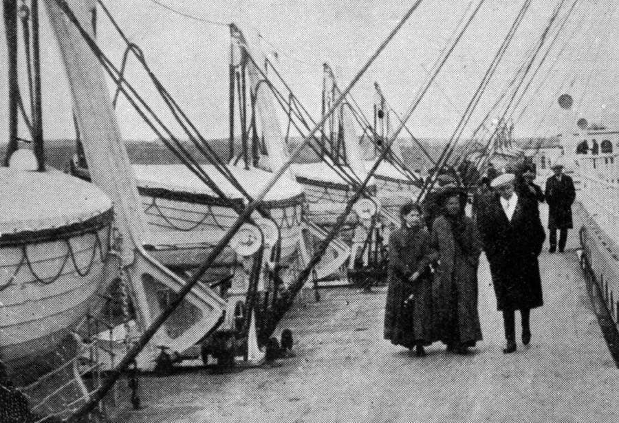 People Walking Past Lifeboats