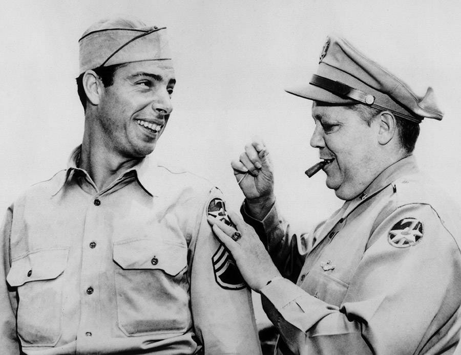 Joe Dimaggio getting a new patch on his WWII uniform