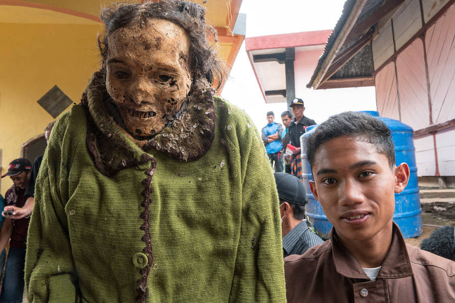 Young Toraja Man Poses With Ancestor Corpse