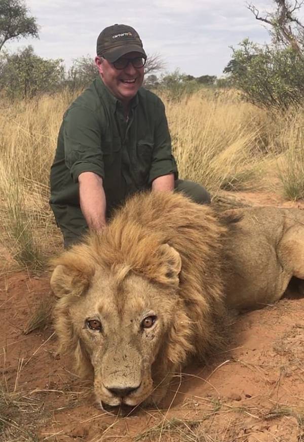 Trophy Hunter With Dead Lion