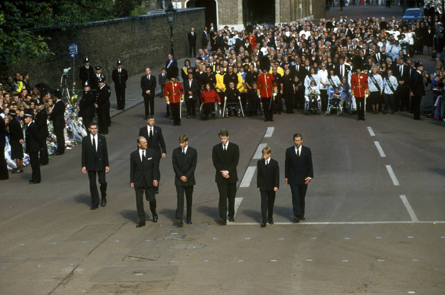 Men In Suits Followed By Large Crowd