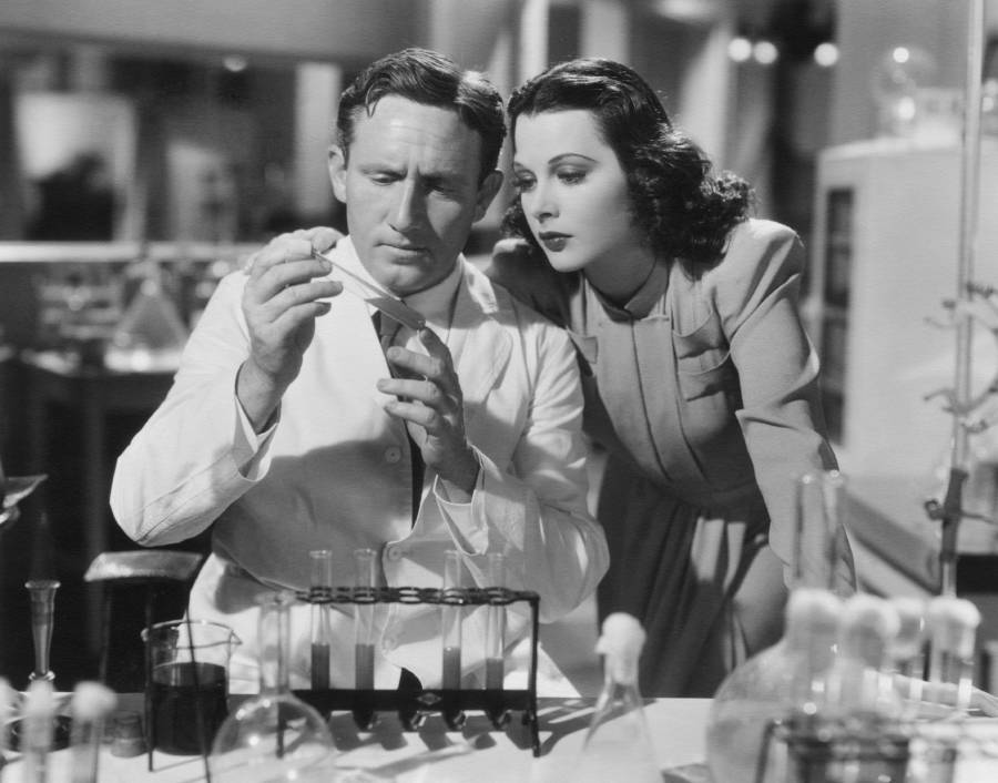 Hedy Lamarr Stands Over Science Equipment