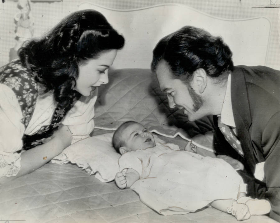 Parents Over Baby On Bed