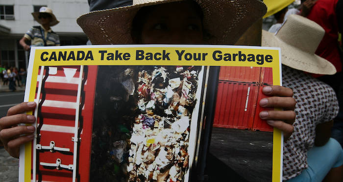 Protester Holds Up Sign Against Canadian Trash