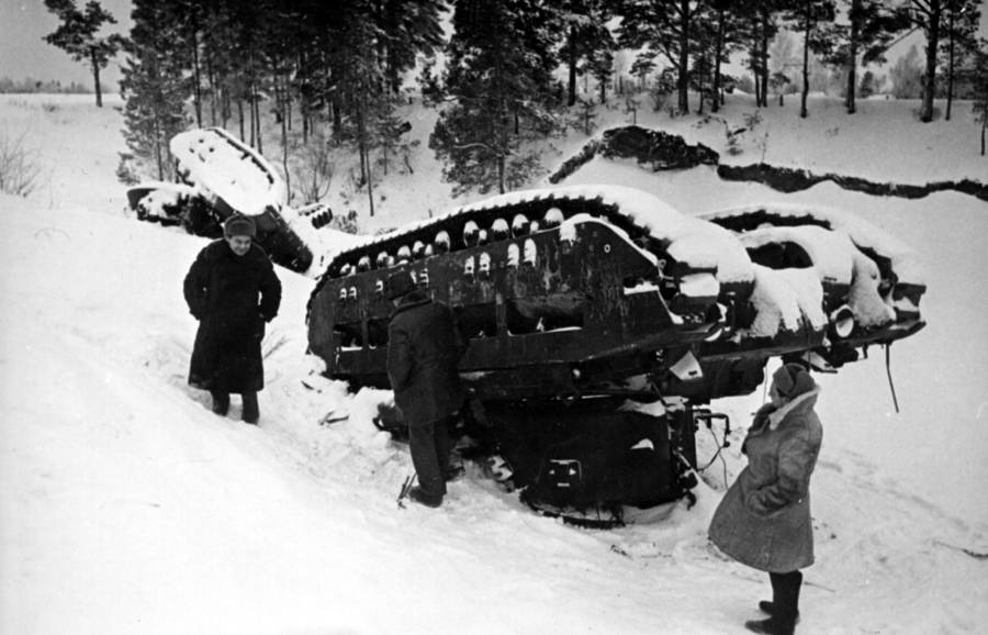 Civilians Inspect Upturned Tank In Snow