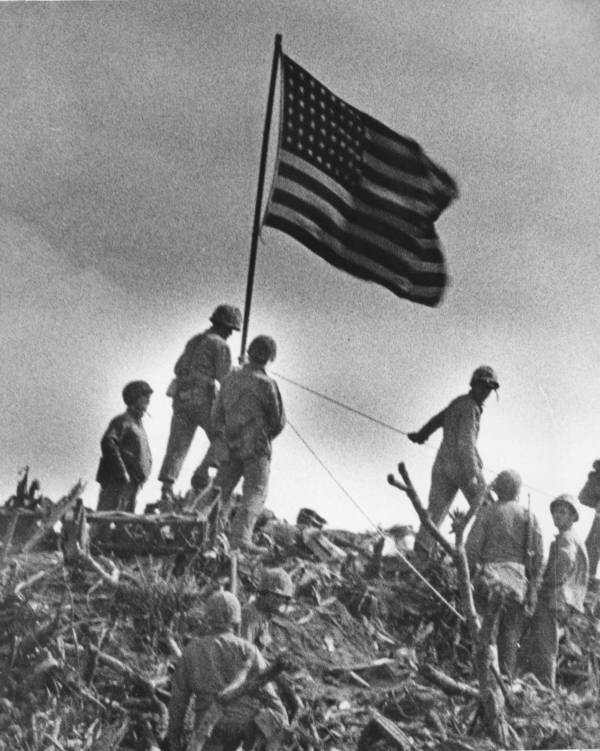 Amerikanische Flagge auf Iwo Jima, umringt von Marinesoldaten.