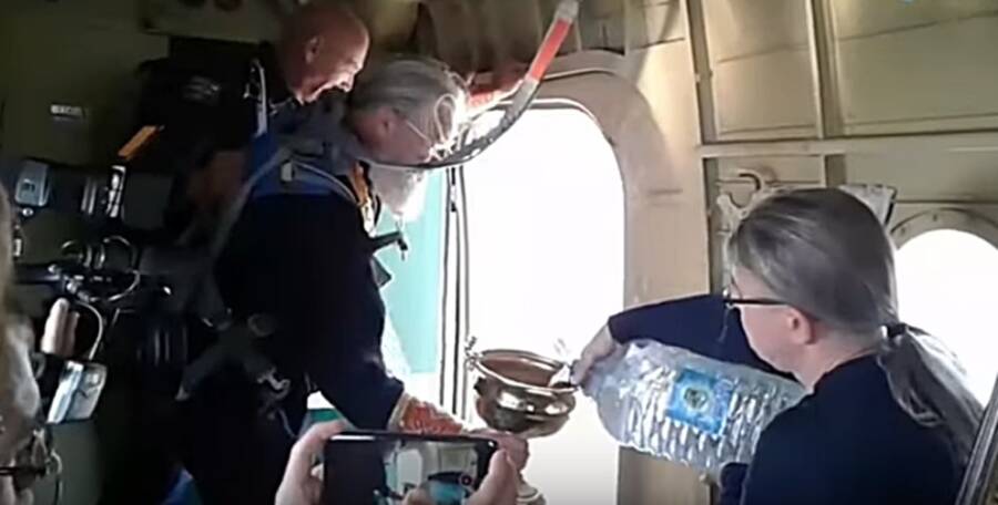 Russian Priests Prepare Holy Water Aboard Airplane
