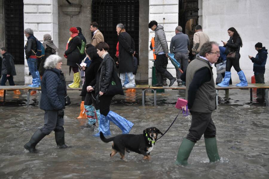 Tourists Walk Through Flood