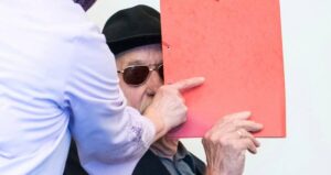 Bruno Dey Peaking Out From Behind A Folder