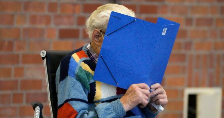 Josef Schutz Covering Face With Blue Folder
