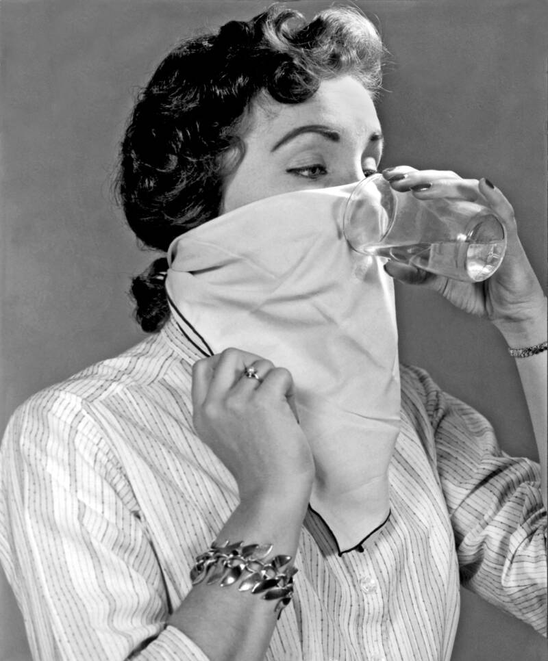 Femme buvant de l'eau à travers un mouchoir