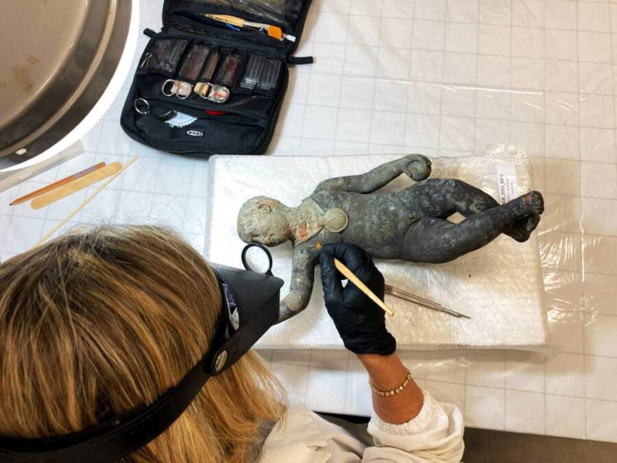 Researcher Examining A Bronze Statue