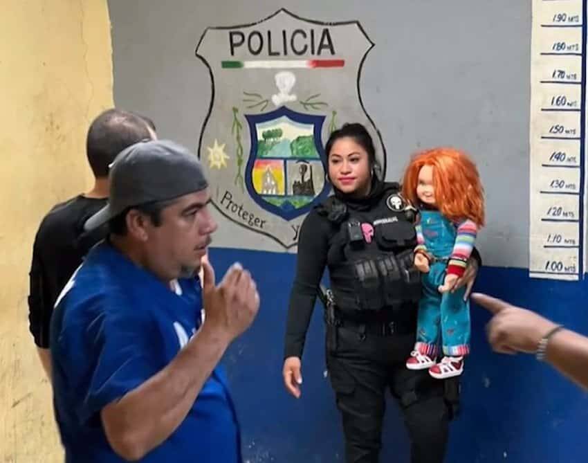 Police Officer Posing With Chucky Doll