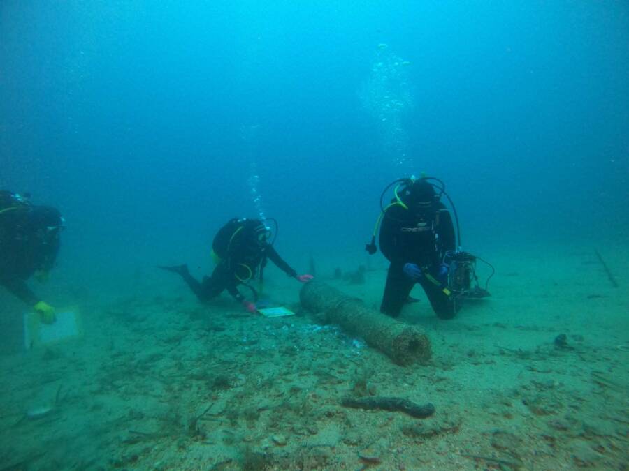 Underwater Archaeologists With Iron Cannon