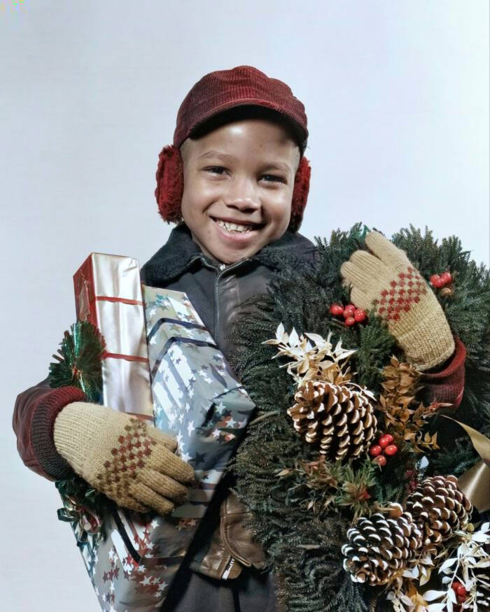 Black Boy Holding Presents And A Wreath