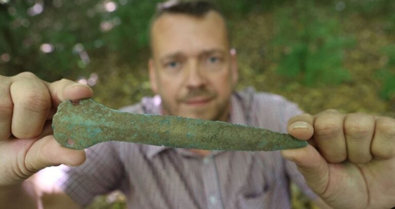 Man Holding Up Gudersleben Dagger Featured