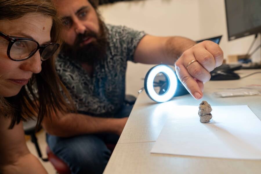 Researchers Examining Woman Goose Figure